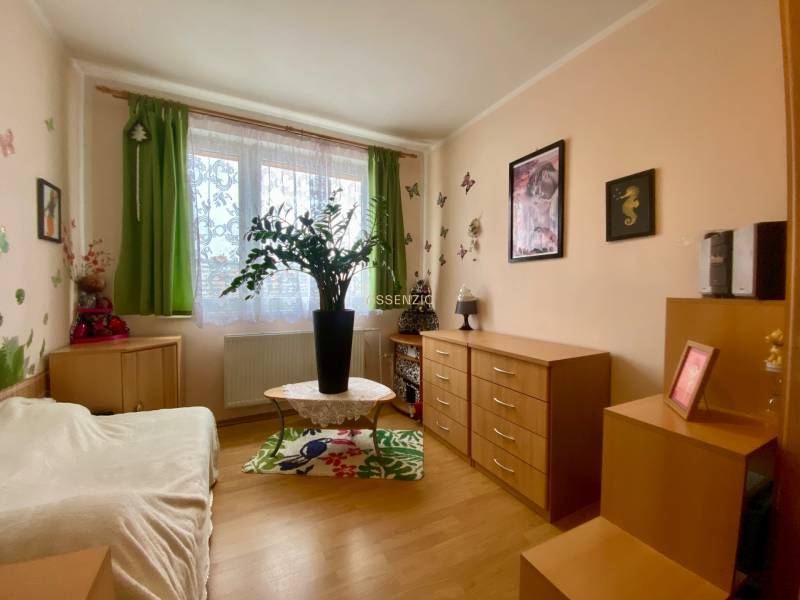 A room in a 3-room apartment with decorations, wooden dressers, and a wooden decor floor.