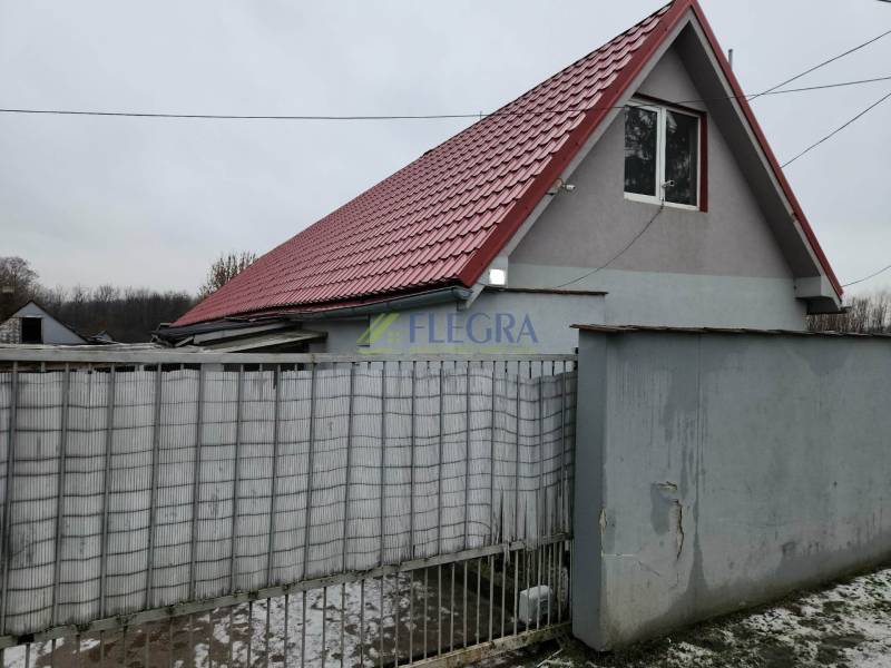 A family house in Tornyosnémeti with a red roof and a gray fence.