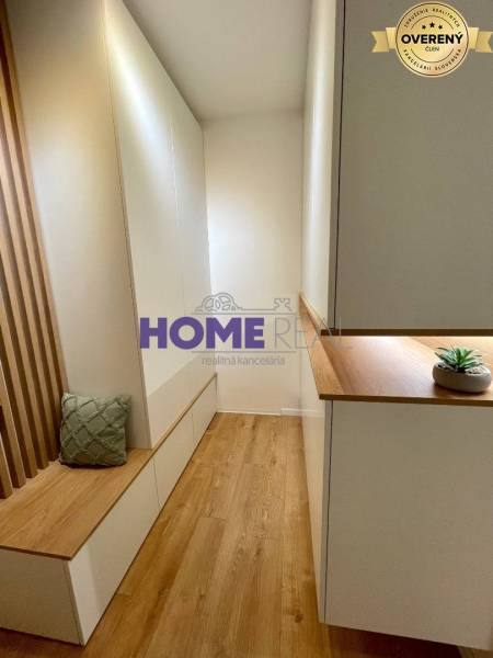 Cozy interior of a 3-room apartment with wood-decor flooring and built-in furniture.