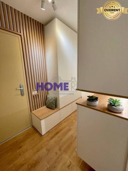 An entrance hall with wooden floor decor and wall cladding in a 3-room apartment.