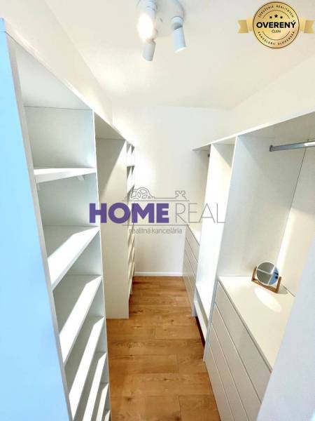 A wardrobe in a 3-room apartment with storage spaces and flooring with a wood decor.