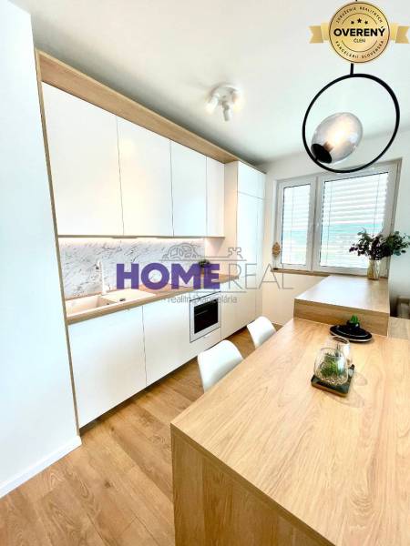 Kitchen in a 3-room apartment with white cabinets and a wooden decor floor.