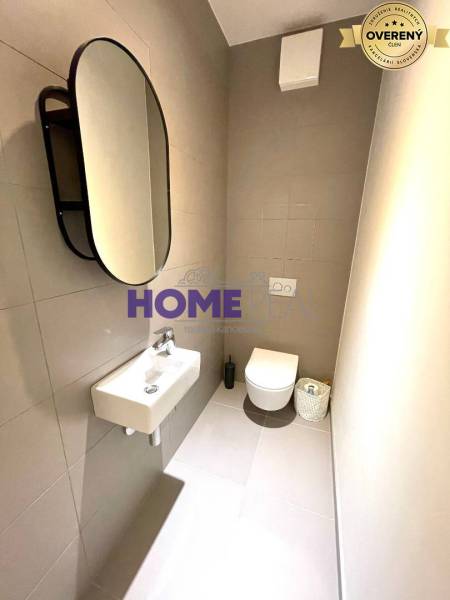 Bathroom in a 3-room apartment with a mirror, sink, and wall-mounted toilet.