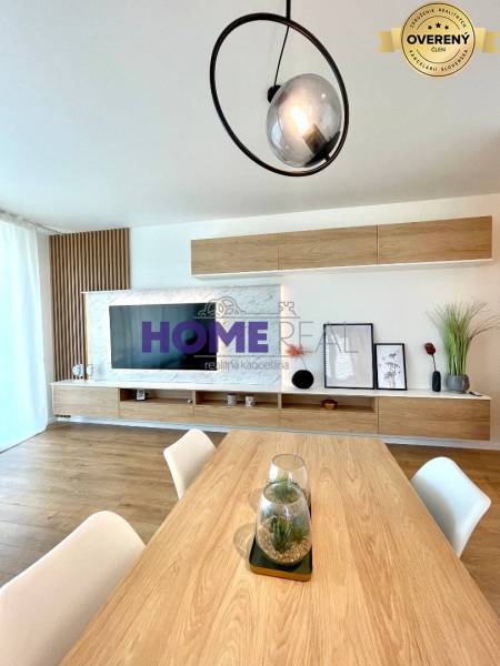 A bright living room in a 3-room apartment with a wooden decor floor and modern linear lighting.
