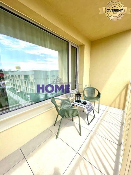A balcony with a view, seating, and a decorative table in a 3-room apartment.