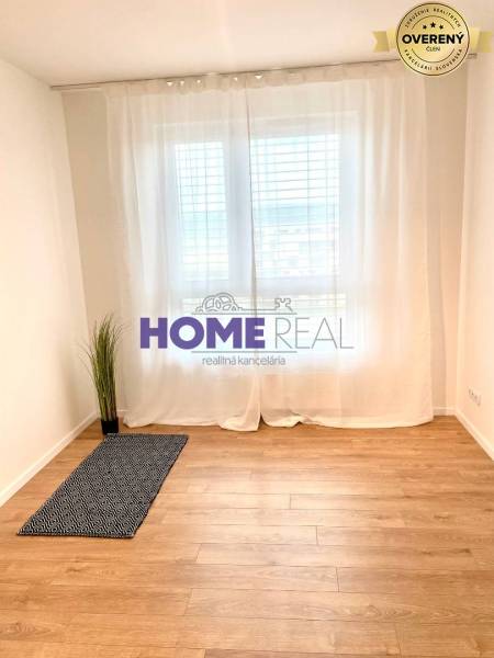 A room with a wooden floor decor and white curtains in a 3-room apartment.