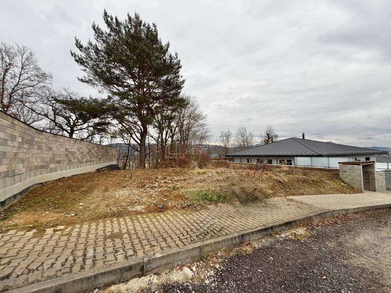 A residential plot in Veľká Bytča in the town of Bytča with a walkway and trees.