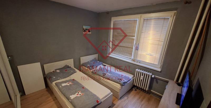 Children's room in a 3-room apartment with two beds and a floor with a wooden decor.