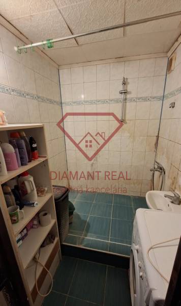 Cozy bathroom with a washing machine, white tiles, and shelves, ideal for a 3-room apartment.