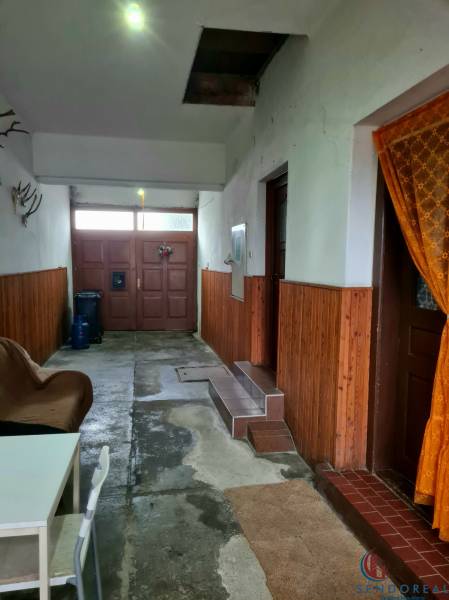 Interior of a family house with entrance doors, a chair, and wall decorations.