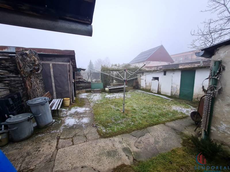 Family house in Chtelnica on Námestie 1. mája with a garden, shed, and waste containers.