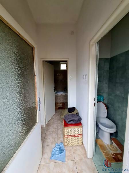 Bathroom and toilet with tiles in a family house, with a storage basket.