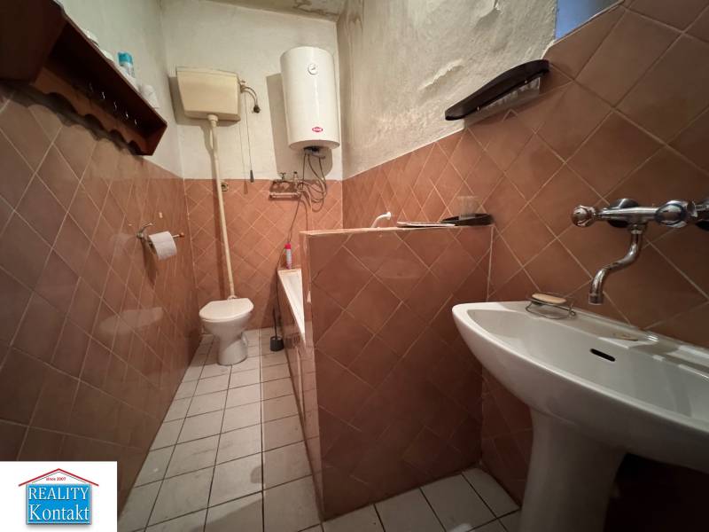 A bathroom in a family house with a gas boiler and ceramic tiles.