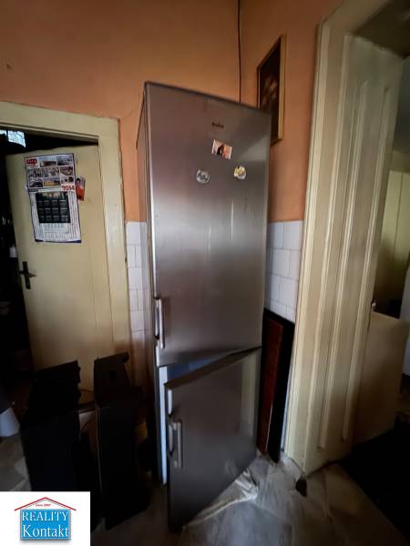 Kitchen of a family house with a refrigerator and a calendar on the wall.