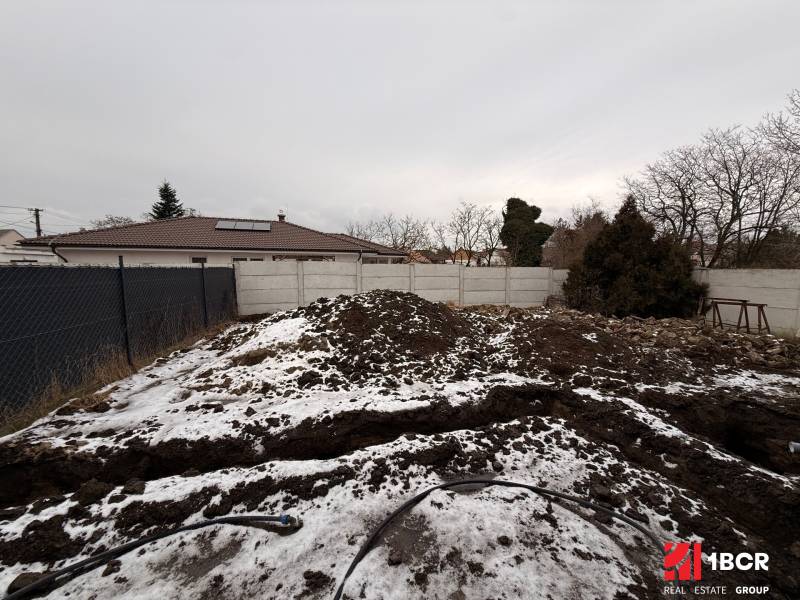 Construction site of a family house in Senec during the winter period with a fence and snow.