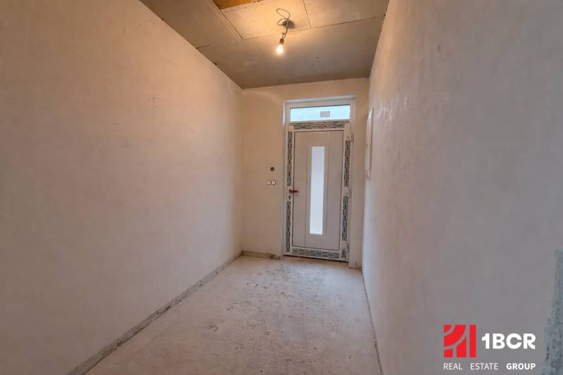 A hallway in a family house with simple lighting and plastic doors.