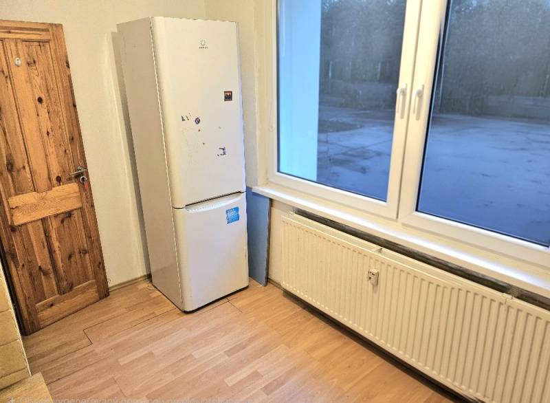 A kitchen corner in a 3-room apartment with an appliance and a wooden decor floor.