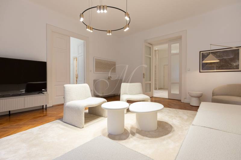 Living room in a 3-room apartment with white furniture and a wooden decor floor.