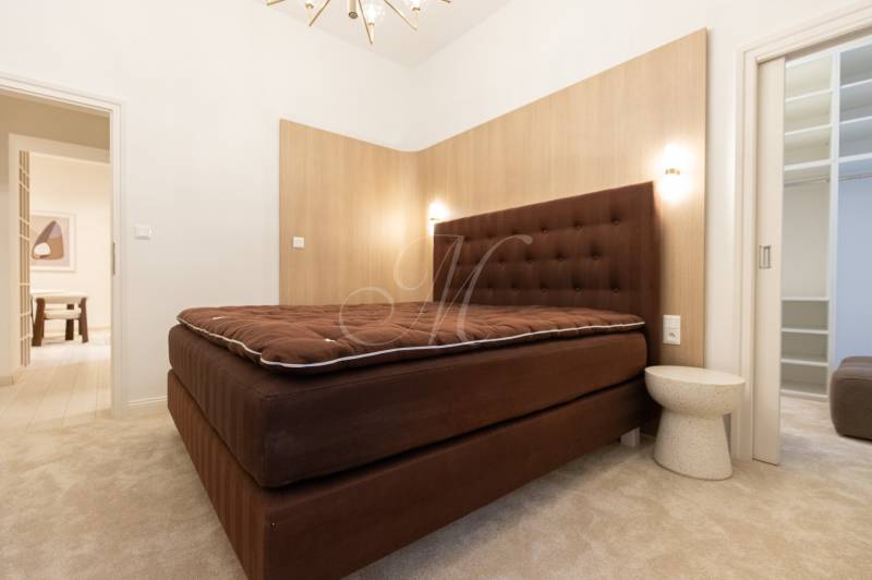 Bedroom in a 3-room apartment with a brown bed and a white table, carpet.