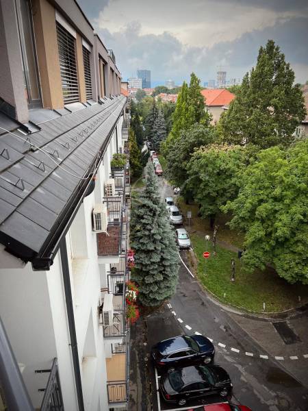 A bird's-eye view of greenery and parked cars in Bratislava - Ružinov on Budovateľská Street.