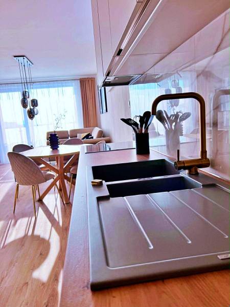 The kitchen in a 3-room apartment with a light wooden decor floor and stylish seating.