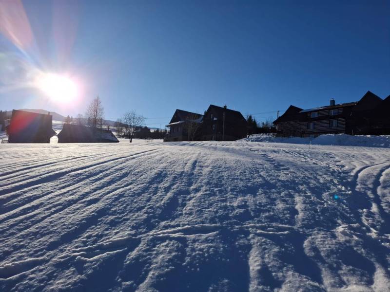 Snow-covered residential plots in Ždiar with an impressive snow-covered hill.