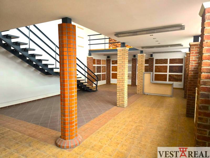 Two-story commercial spaces with wood-patterned flooring and a staircase.