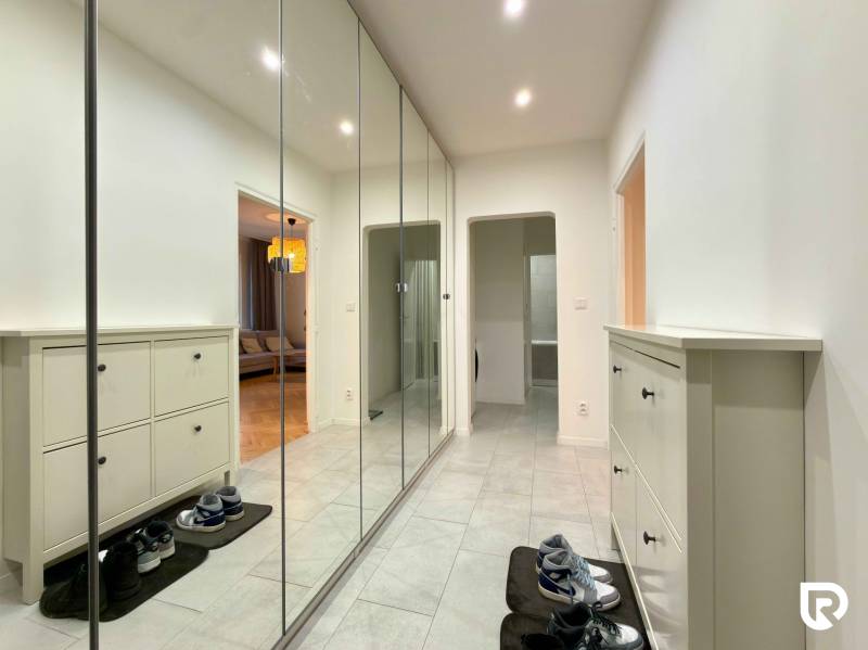 Hallway with a large built-in wardrobe and shoe cabinet in a 2-room apartment with tiled flooring.