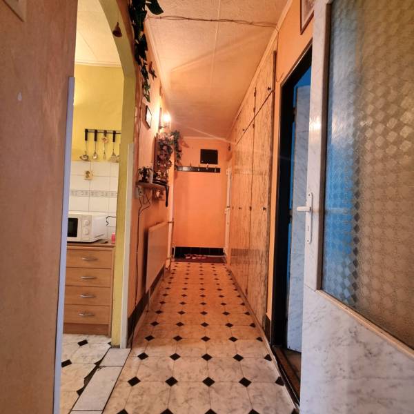 A cozy hallway with an entrance to the kitchen and tiles in a 3-room apartment.