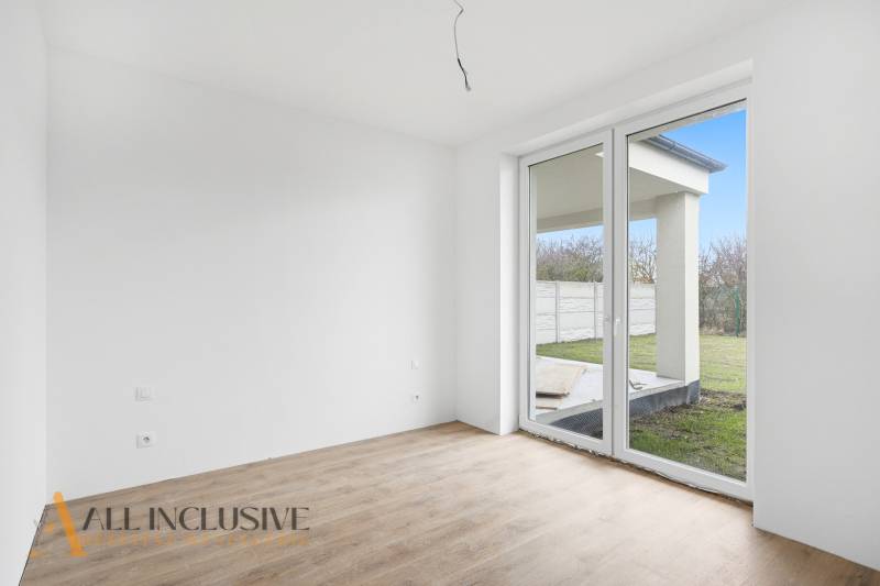 A room in a family house with a large window and a wooden decor floor.