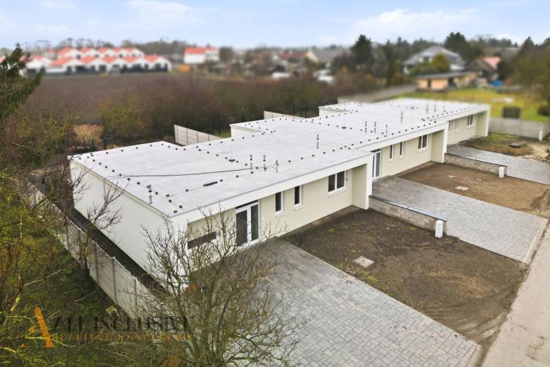 A family house in Čukárska Paka in Veľká Paka with a flat roof and paved parking.
