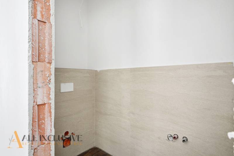 Interior of a family house with an exposed brick wall and tiling in the bathroom.