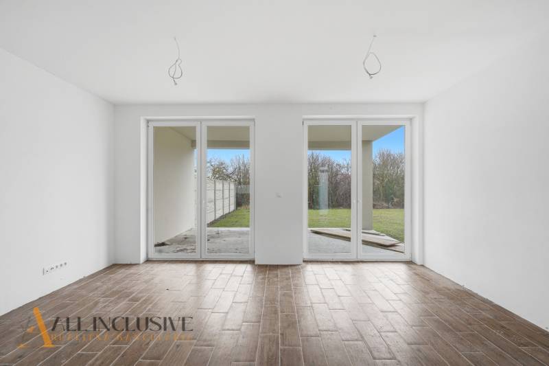 In the family house, there is a spacious room with large windows and a floor with a wooden decor.