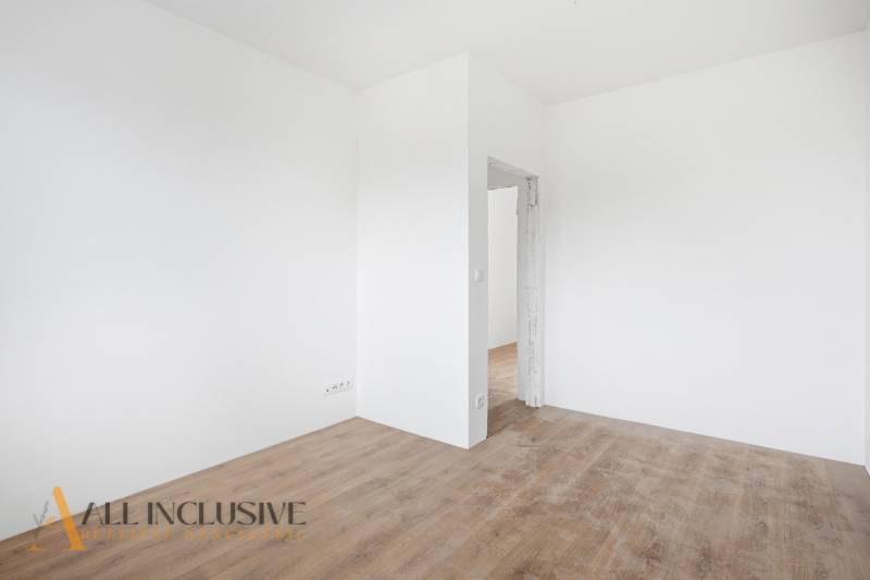 White room with wood-patterned flooring in a family house.