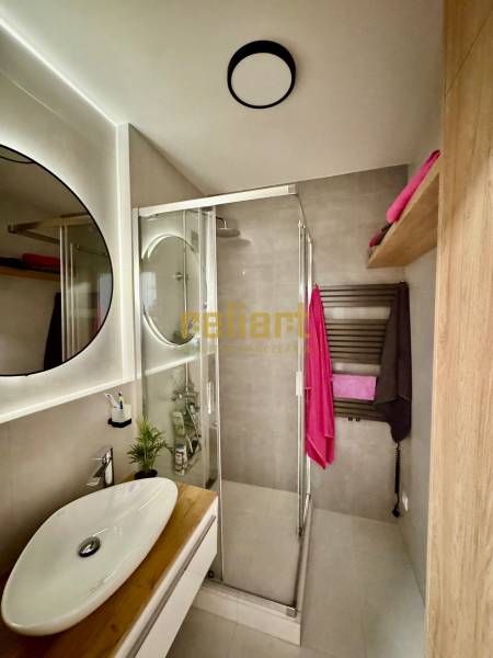 Bathroom with shower, sink, and storage space in a 3-room apartment.