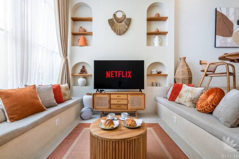 A comfortable living room in a villa with a television, cushions, and decorations, coffee is being served.