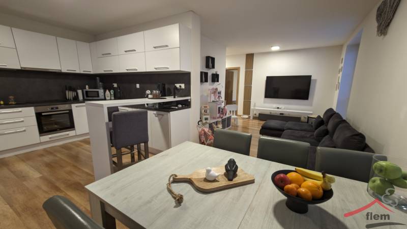 Kitchen with living room in a 2-room apartment, light cabinetry, floor with wood decor.