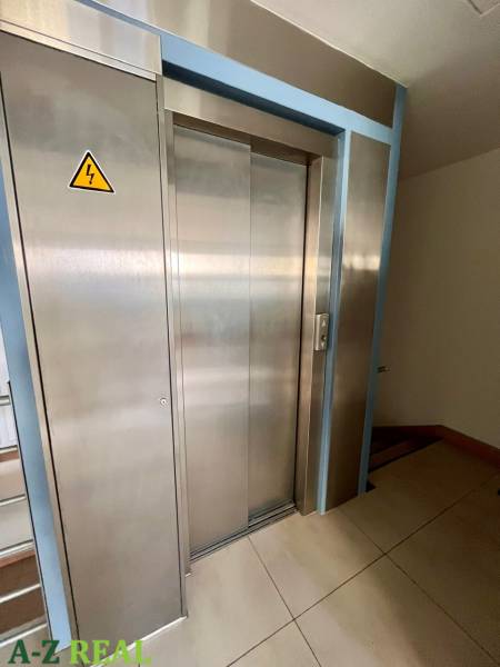 Stainless steel elevator in offices with tiled flooring.