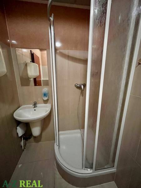 Shower corner and sink in the bathroom of rental offices.