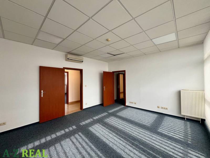 Offices with carpeted floors, white walls, ceiling panels, and air conditioning.