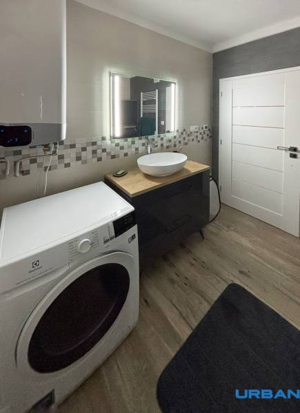 Bathroom with a washing machine and a sink in a 3-room apartment, small mosaic on the wall.