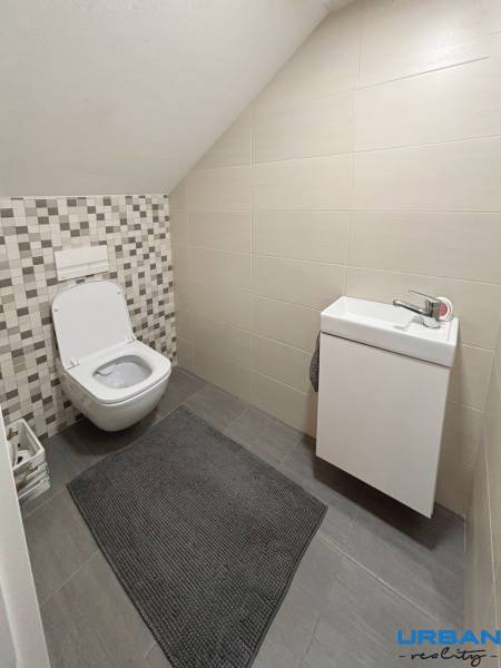 A bathroom in a 3-room apartment with a toilet and a sink, tiles with a geometric pattern.