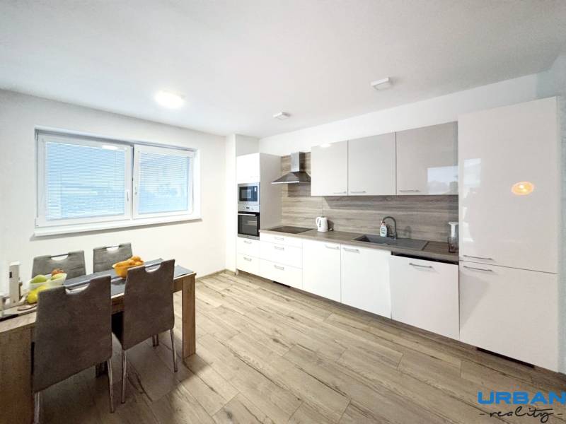 A kitchen in a 3-room apartment with a modern kitchen unit and a floor with a wooden decor.