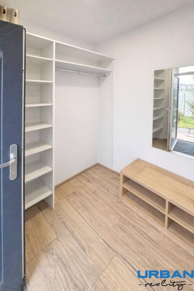 A hallway with shelves and a wooden decor floor in a 3-room apartment.