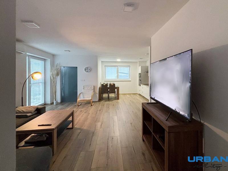 Living room in a 3-room apartment with a sofa, television, and wooden decor flooring.