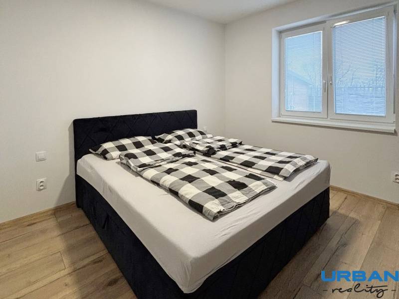 Bedroom with a double bed and a wooden decor floor in a 3-room apartment.