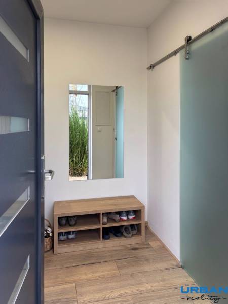 3-room apartment with a shoe bench, mirror, and wooden decor flooring.