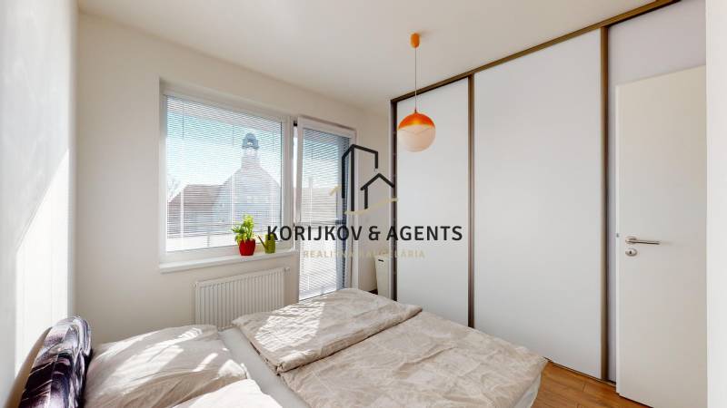 Bedroom with a sliding wardrobe and a bed in a 2-room apartment, floor with wooden decor.