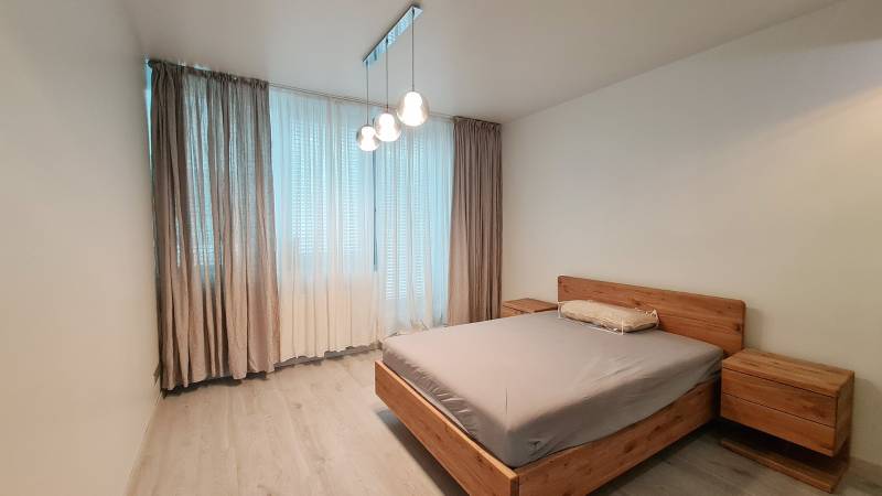 Bedroom in a 3-room apartment, wooden furniture, floor with wooden decor, curtains.