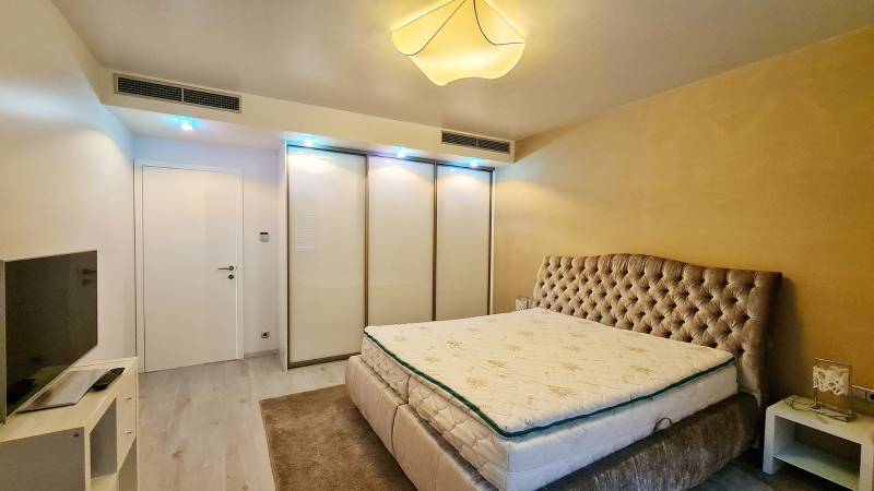 A bedroom with a comfortable bed, built-in wardrobe, and television in a 3-room apartment.